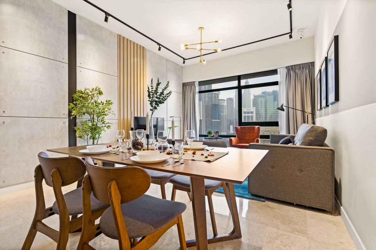 Un espace repas moderne avec une table en bois, des chaises et un canapé.