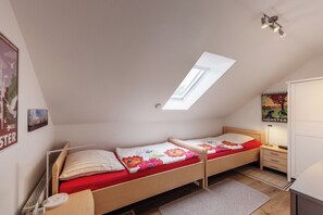 A dorm-style room with a skylight, a bed with floral bedding, a desk, and a radiator. - NATURE and PEACE 🍀 Cozy, quiet 2-room vacation apartment in Münster (Münster)