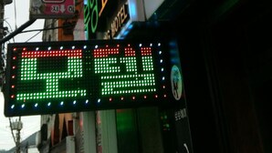 A hotel sign with Korean characters, a neon sign, and a digital display. - Booyoung Motel (Geoje)