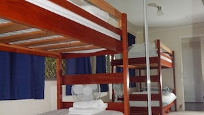 A room with two bunk beds, a ceiling fan, and a door leading to another room. - Manly Peninsular (Wynnum)