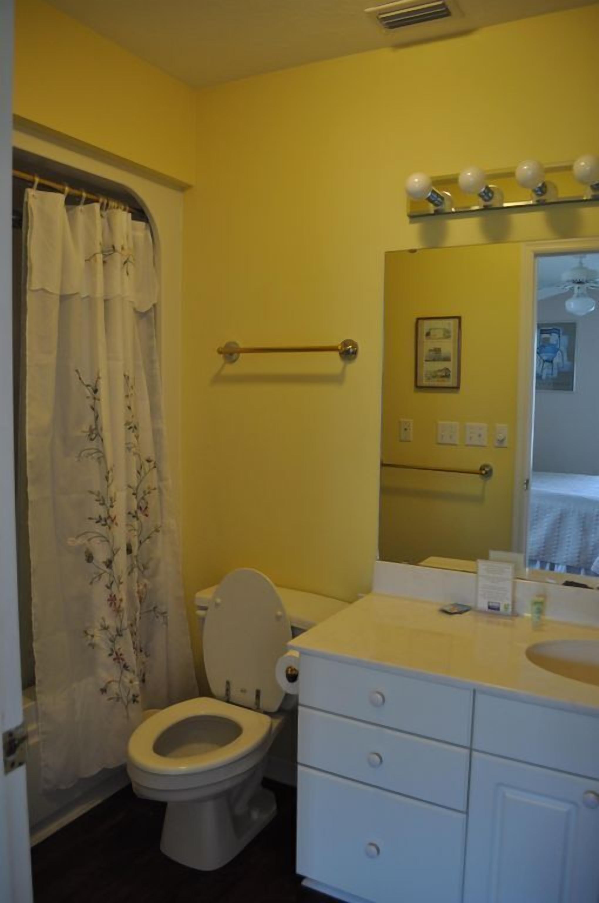 Ein Badezimmer mit Toilette, Waschbecken und Spiegel.