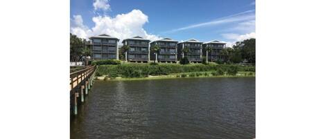 A waterfront hotel with multiple balconies overlooking a body of water.