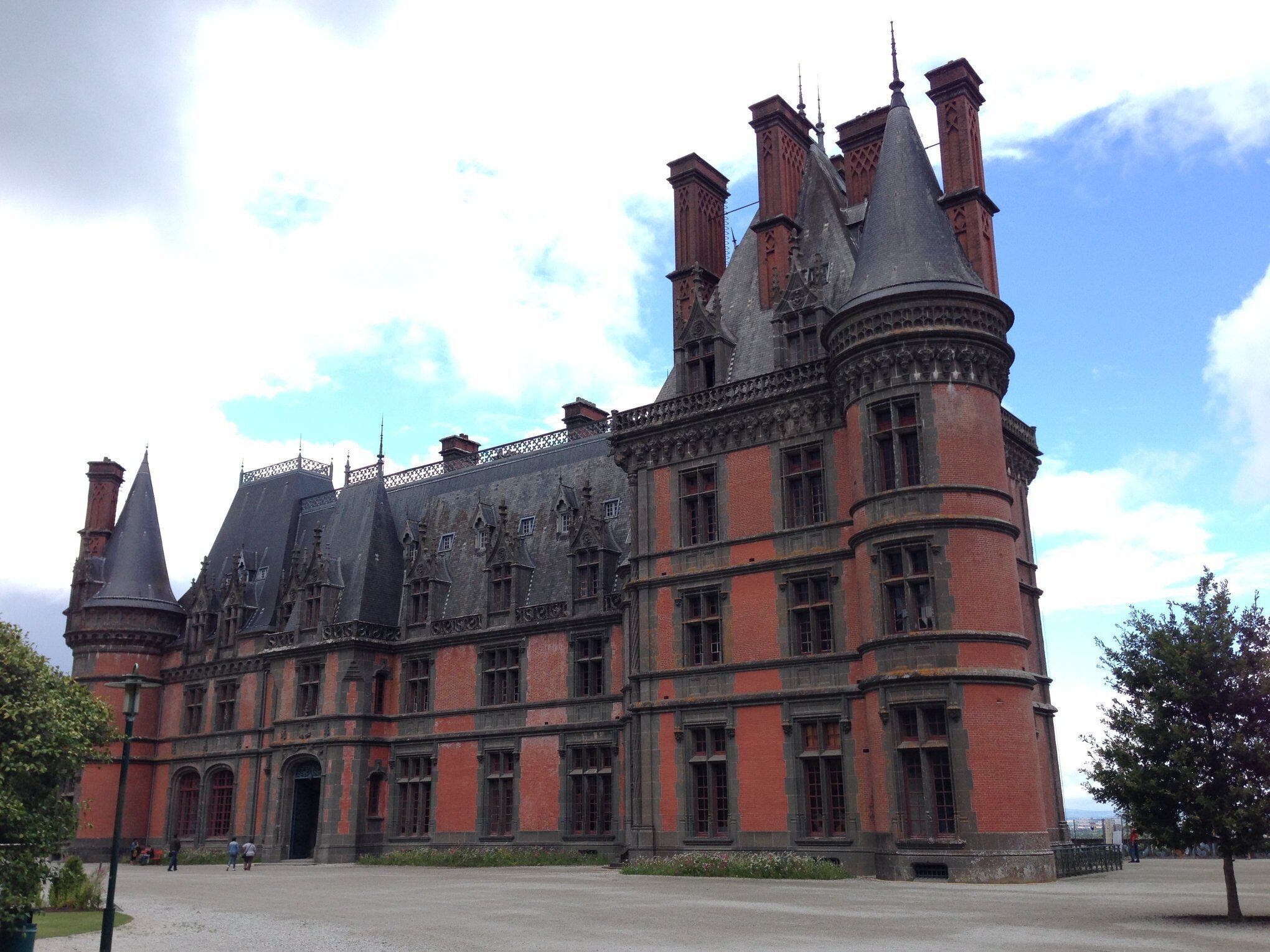 Un grand bâtiment historique doté de nombreuses tours et d’une cour intérieure.