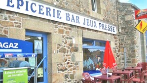 Un edificio de piedra con un letrero que dice 'EPICERIE BAR JEUX PRESSE'.