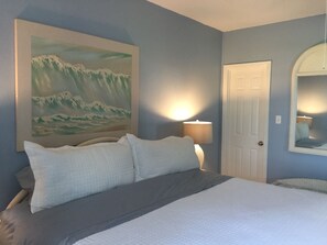 Ein Schlafzimmer mit einem Bett, einem Bergpanorama, einer Lampe und einer Tür.