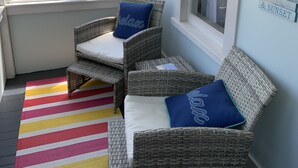 A cozy seating area with wicker chairs and a colorful striped rug. - Charming House Located In Downtown Grand Haven (Grand Haven)