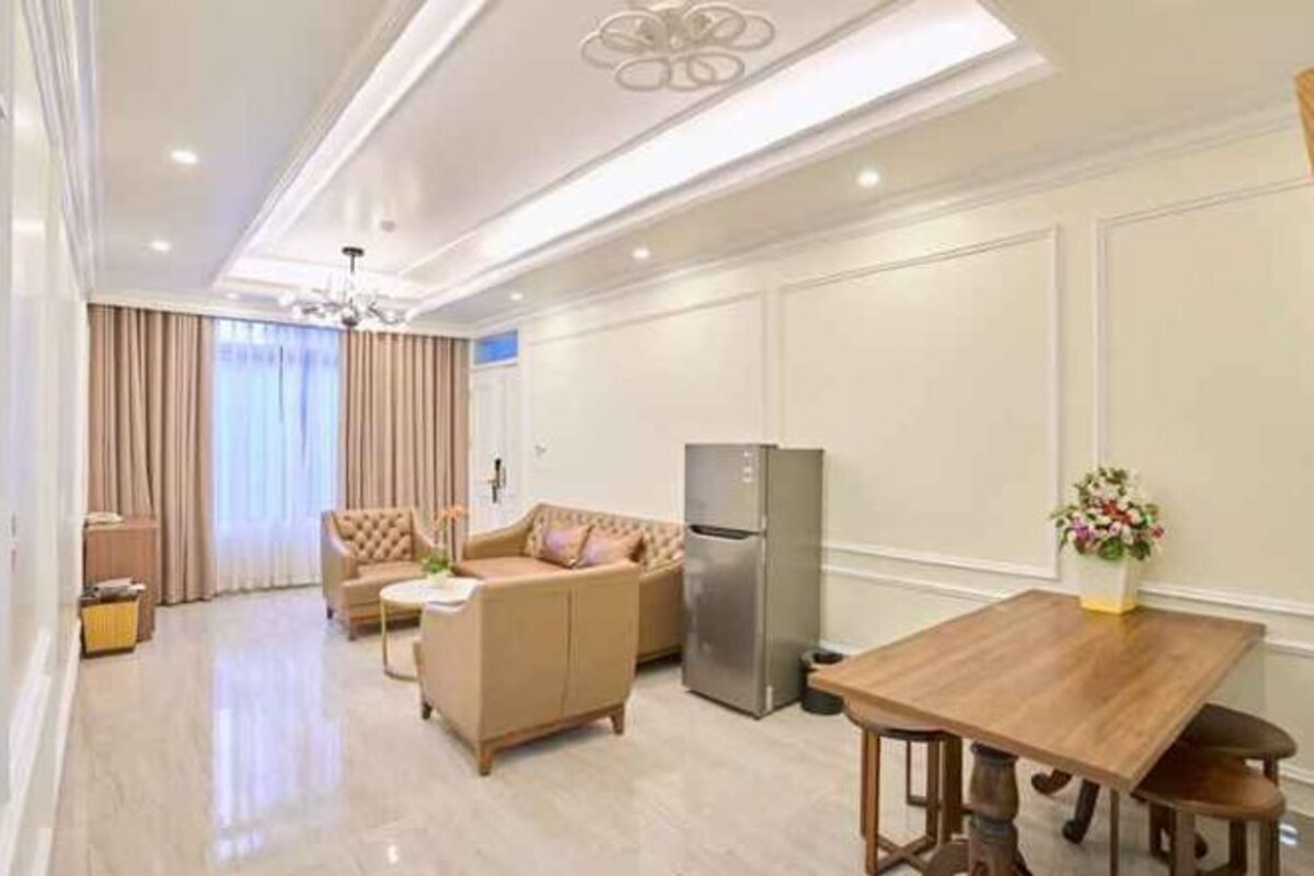 Una sala moderna con sofá, mesa de comedor y refrigerador.
