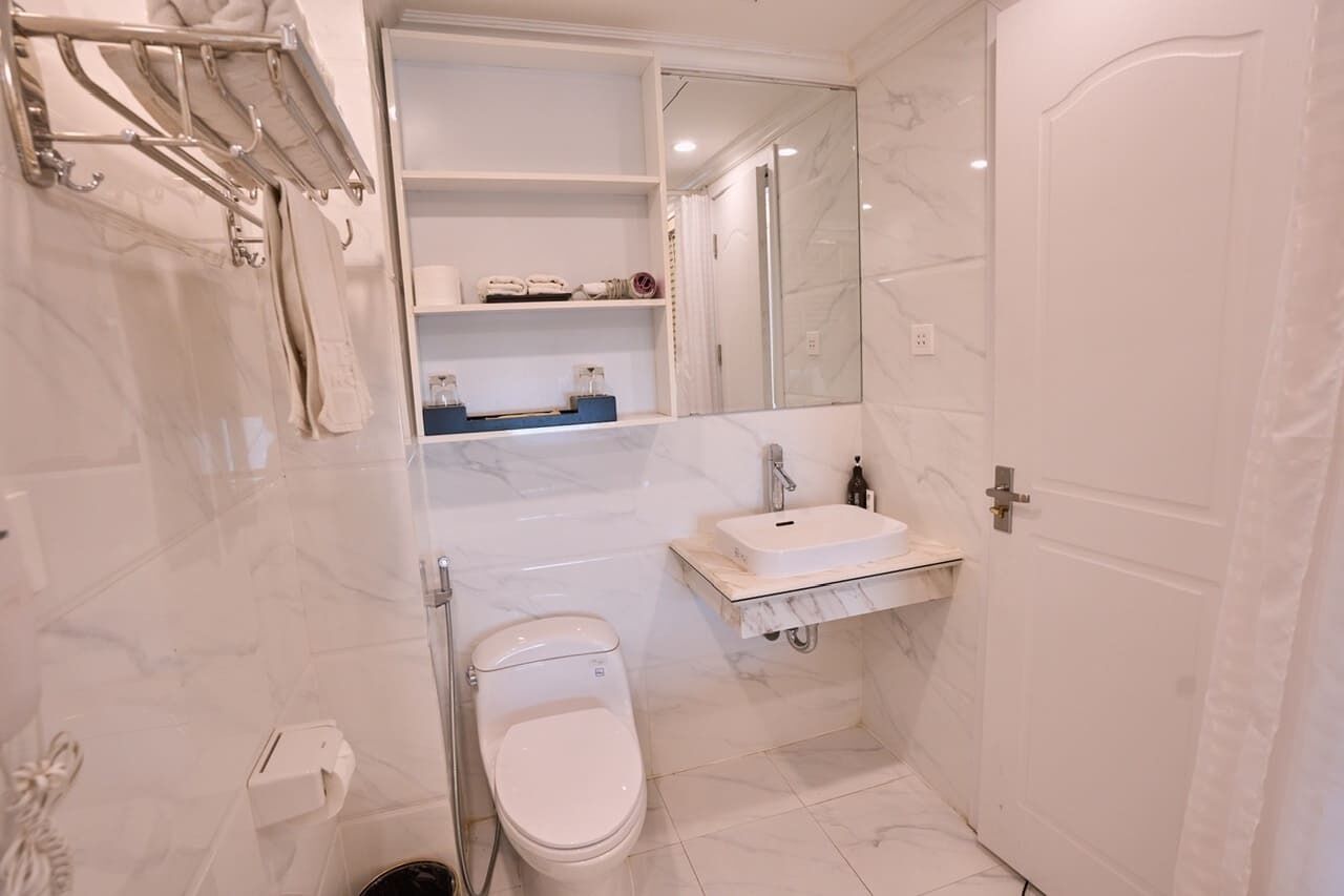 A modern bathroom with a toilet, sink, and towel rack.