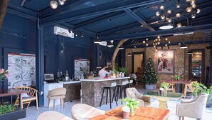 A modern restaurant with a bar area, seating arrangements, and a Christmas tree. -  Le Haute Hotel Hai Phong (Hai Phong)