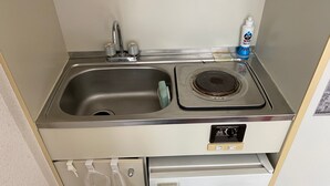 A compact kitchenette with a stainless steel sink, a stove, and a small refrigerator. - Olympic Park Large Balcony Near Shibuya (Setagaya)