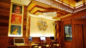 A traditional wooden room with a desk, chairs, and two monitors. - Chanthapanya Hotel (Vientiane)