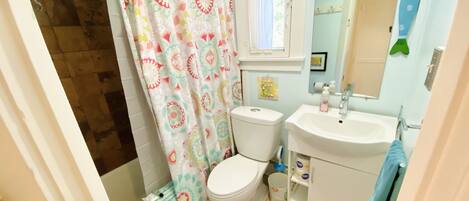 A bathroom with a toilet, sink, and shower curtain.