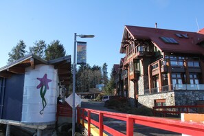 A building with a red roof, stone walls, and a balcony. - Great Condo in Excellent Location - Waterfront Building - Seaside (Ucluelet)