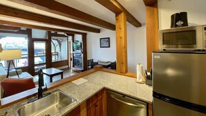 A kitchen with granite countertops, a stainless steel refrigerator, and wooden cabinets.