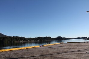 A wooden pier extending into a calm lake with a forested shoreline in the background. - Great Condo in Excellent Location - Waterfront Building - Seaside (Ucluelet)