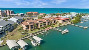 A marina with docked boats, a building with a red roof, and a view of the ocean. - Bay Watch - Waterfront - Walk to beach and restaurants - Dock your boat (Englewood)