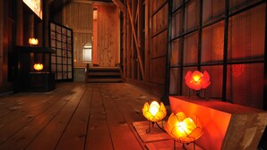 Een houten interieur met een trap, houten vloeren en traditionele lantaarns.