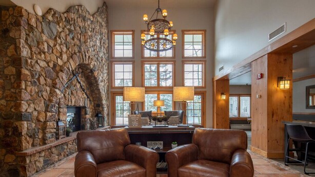 A stone wall, leather chairs, a chandelier, and a fireplace. - 8562 | Pool & Hot tub OPEN, Steps to Gondola. (Keystone)
