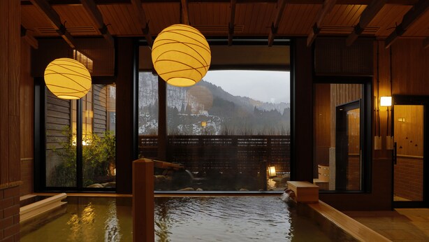 A traditional Japanese onsen with wooden interiors and a view of snow-covered mountains. - Onyado Yuinosho (Shirakawa)