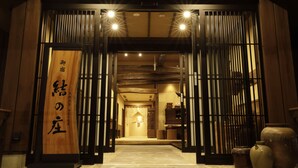 A traditional wooden entrance with a sign, a corridor leading inside, and a reception area with a desk and chairs. - Onyado Yuinosho (Shirakawa)