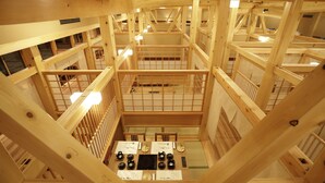 A multi-level wooden structure with a central open area featuring tables and chairs, surrounded by wooden railings and multiple levels of balconies. - Onyado Yuinosho (Shirakawa)