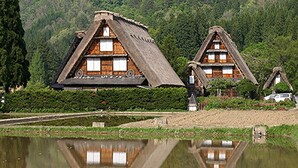 Traditional thatched-roof houses with wooden interiors, situated by a calm lake with reflections. - Onyado Yuinosho (Shirakawa)