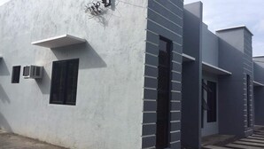 A modern building with a flat facade, large windows, and a clean, minimalist design. - Cris Place Dumaguete (Valencia)