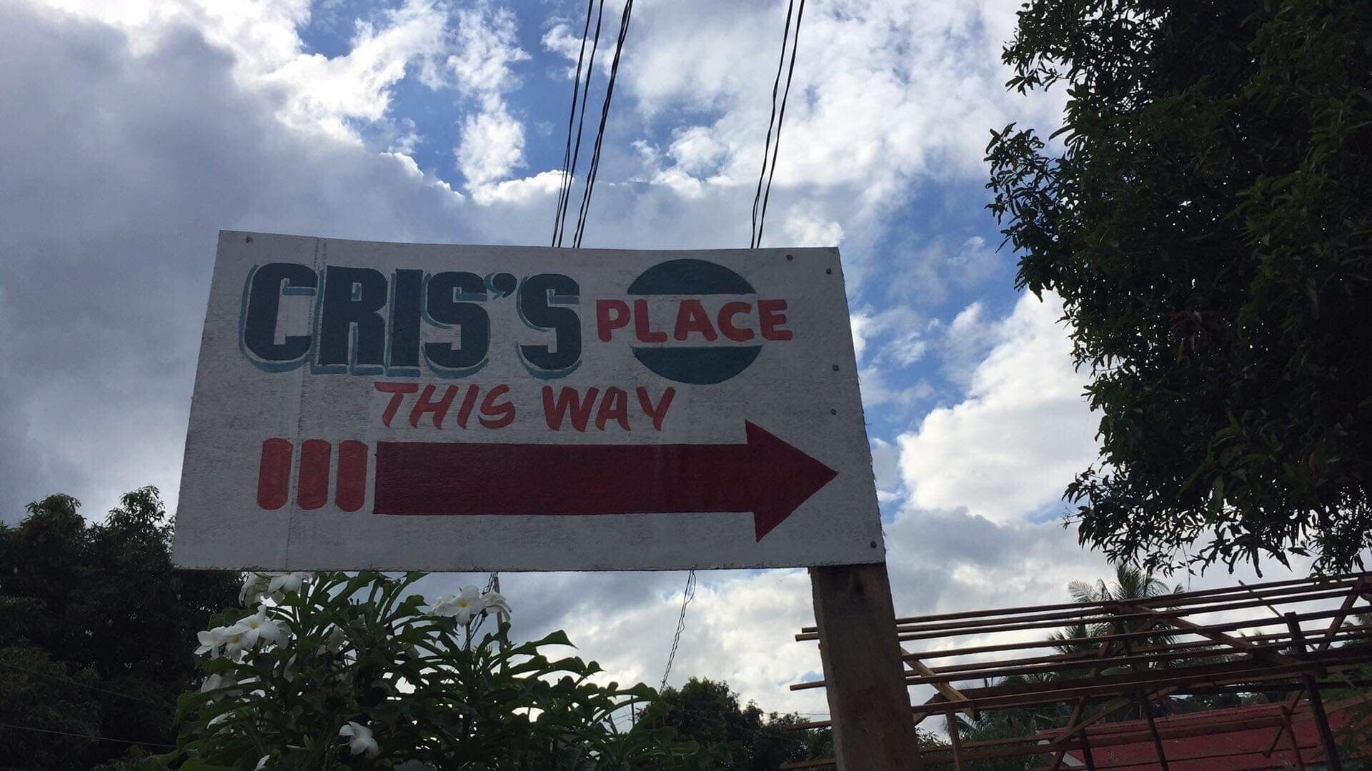 Ein Schild mit dem Text 'CRIS'S PLACE THIS WAY' und einem nach rechts zeigenden Pfeil.