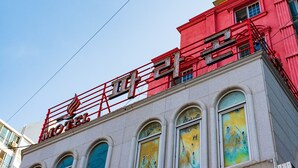 Un edificio rojo con un letrero que dice "Motel" y un balcón.