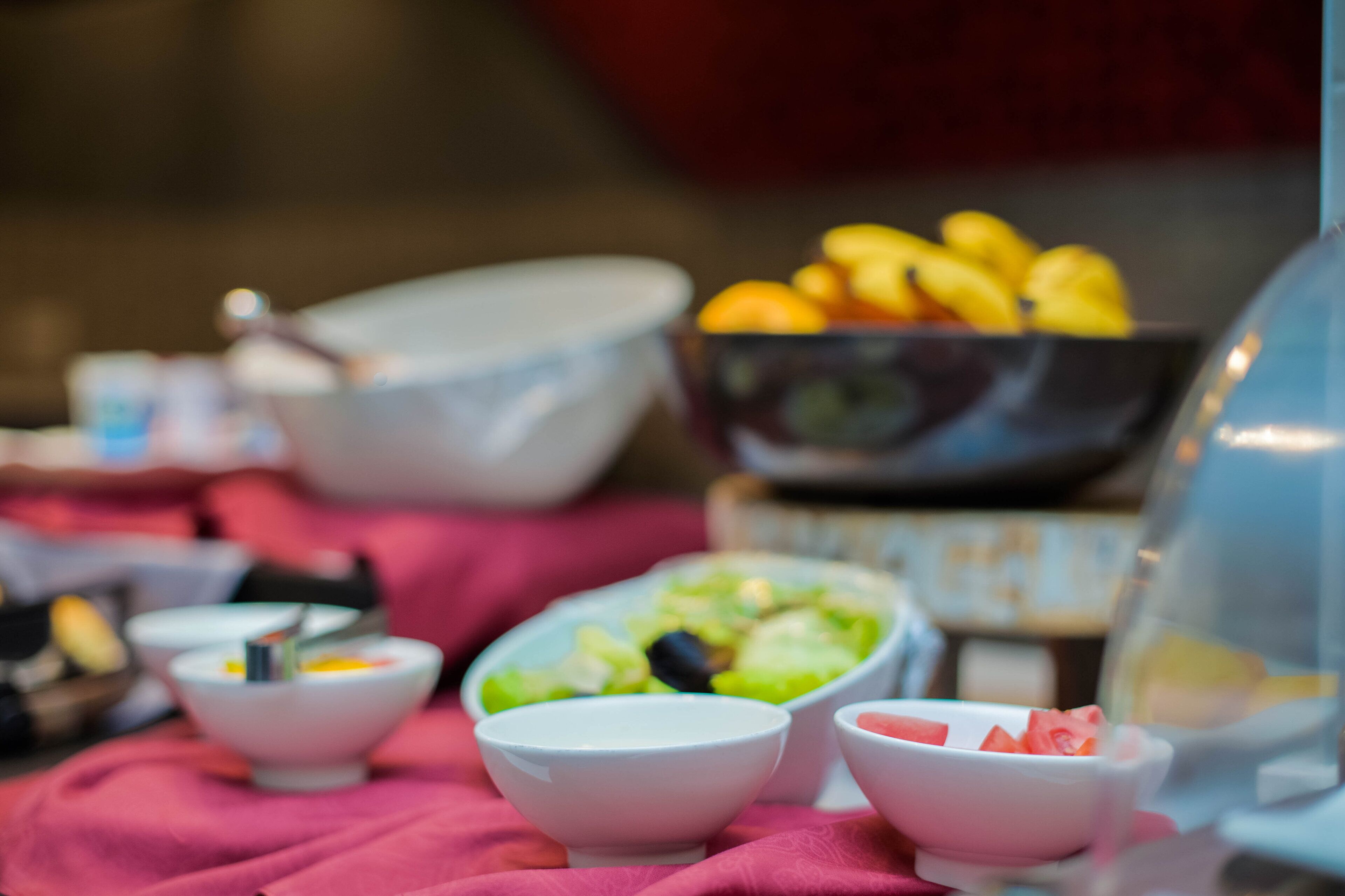 A buffet table with various bowls of food, including fruits and salads.