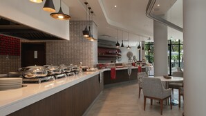 A modern restaurant with a long counter, pendant lighting, and a view of the outdoors. - Crowne Plaza Dar es Salaam by IHG (Dar es Salaam)