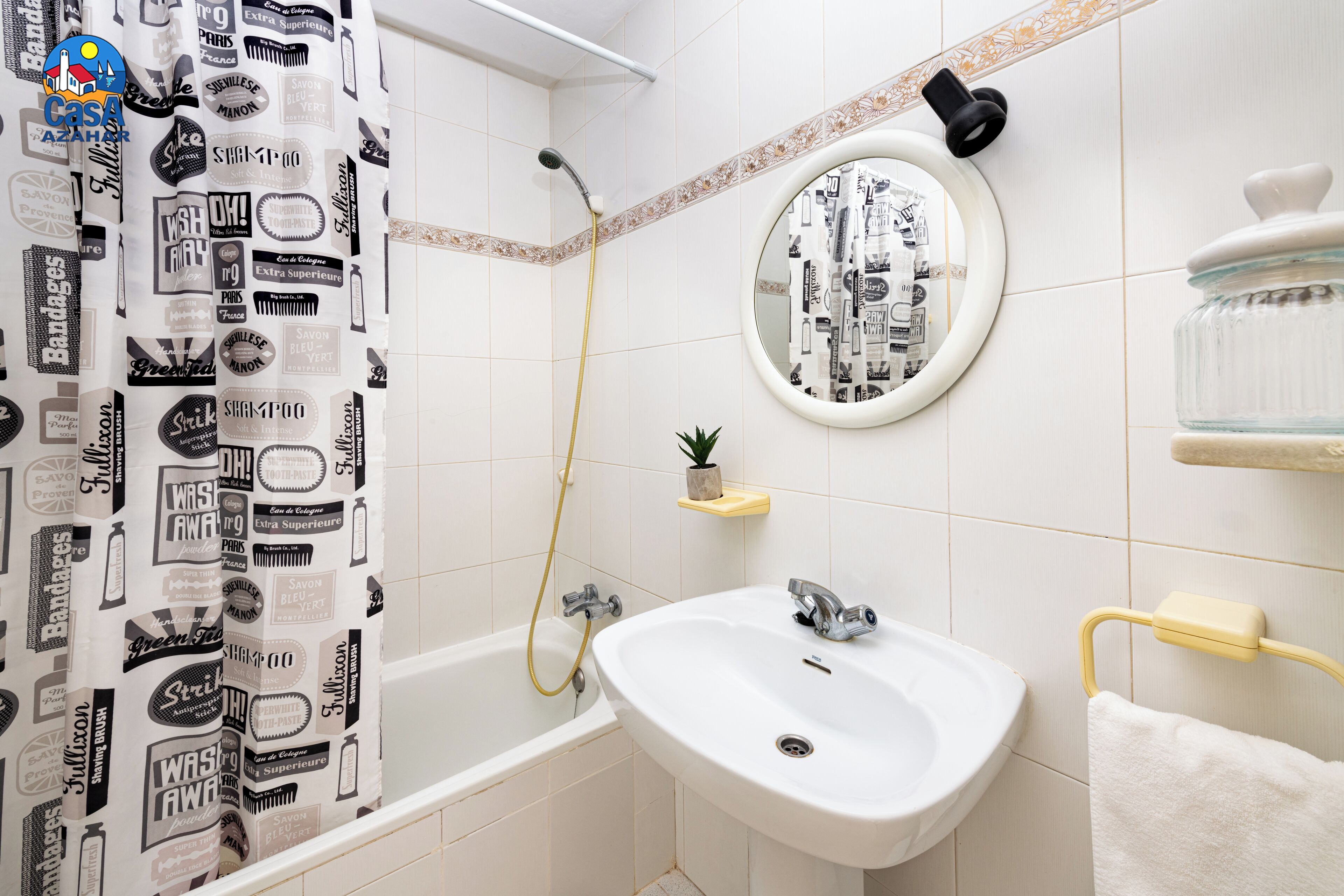 A bathroom with a shower, a sink, a mirror, and a towel rack.