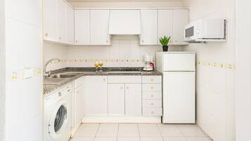 Appartement | Privékeuken | Een koelkast met diepvriezer, een microgolfoven