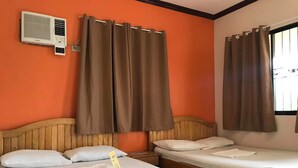 A hotel room with two beds, brown curtains, an air conditioning unit, and a wooden headboard. - John Verhel Homes and Island Tours (Panglao)