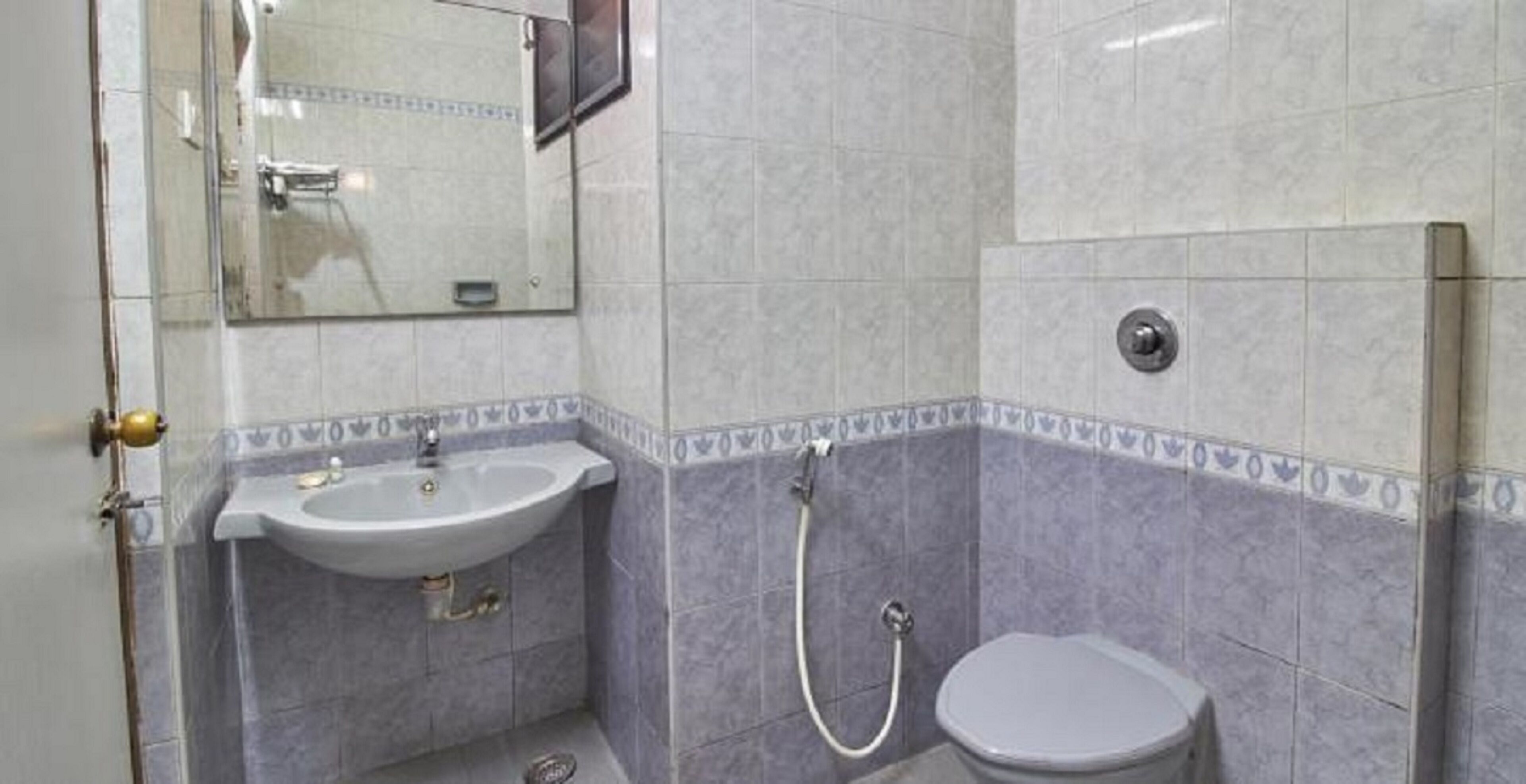 Casa de banho com lavatório, sanita e chuveiro.