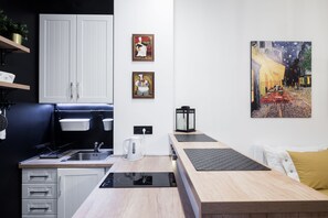 Appartement Deluxe | Cuisine privée | Réfrigérateur, plaque de cuisson, bouilloire électrique, chaise haute