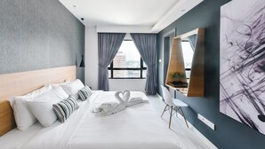 A modern hotel room with a large bed, a view of the city, and a large abstract painting on the wall. - Suasana Suites by Subhome (Johor Bahru)