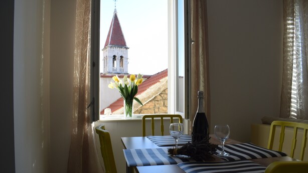 A dining area with a table set for two, a bottle, and a glass on the table. - Optimist Makarska Town Center (Makarska)