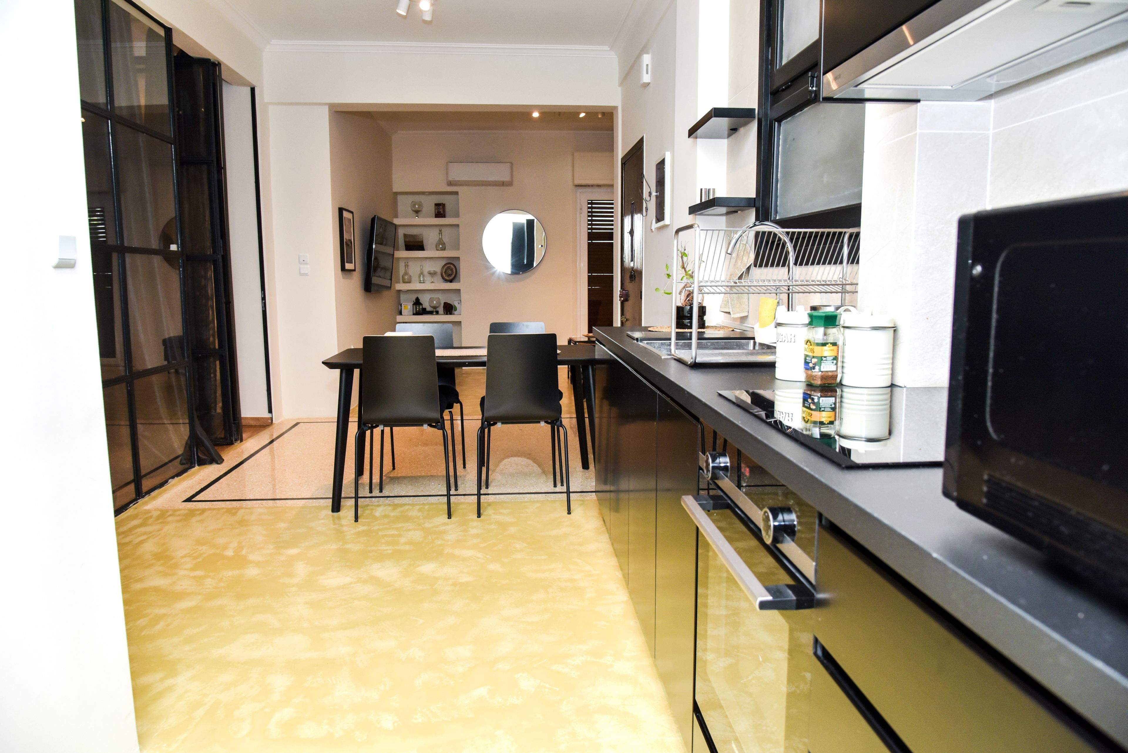 Une cuisine moderne avec un coin repas, comprenant un îlot de cuisine, des chaises et un four à micro-ondes.