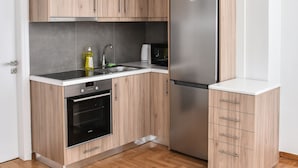 A modern kitchen with light wood cabinets, a stainless steel refrigerator, and a built-in oven. - Modern  Apartment at Exarchia 1 bed 2 pers  (Athens)