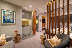 Un interior moderno con un sofá, una mesa decorativa con una botella y un cuadro en la pared.