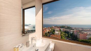 A modern bathroom with a large window offering a city view.