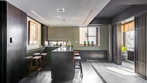 Cozinha moderna com ilha central, banquetas e vista para a área de jantar adjacente.