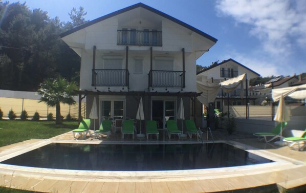 Utomhuspool, parasoller och solstolar