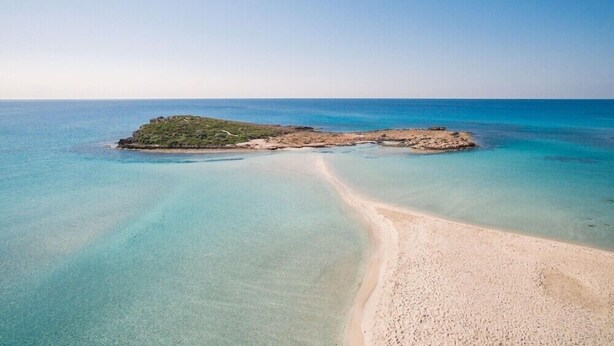 A coastal landscape with a sandy beach and a small rocky island. - Nissi Beach Resort (Ayia Napa)