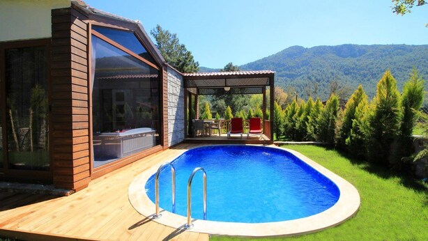 Una piscina al aire libre, sombrillas, sillones reclinables de piscina