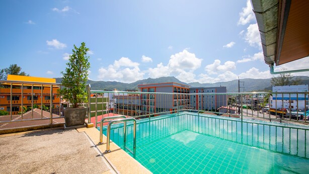 Una piscina en la azotea con vistas a edificios y montañas.
