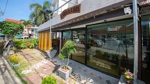 Un escaparate con un letrero que dice "KAHALA COOL" y una cámara de seguridad montada en la pared.