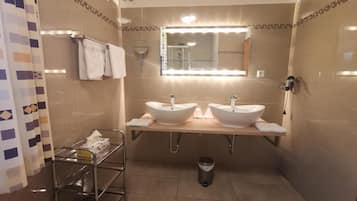 A bathroom with two sinks, a mirror, and a towel rack.