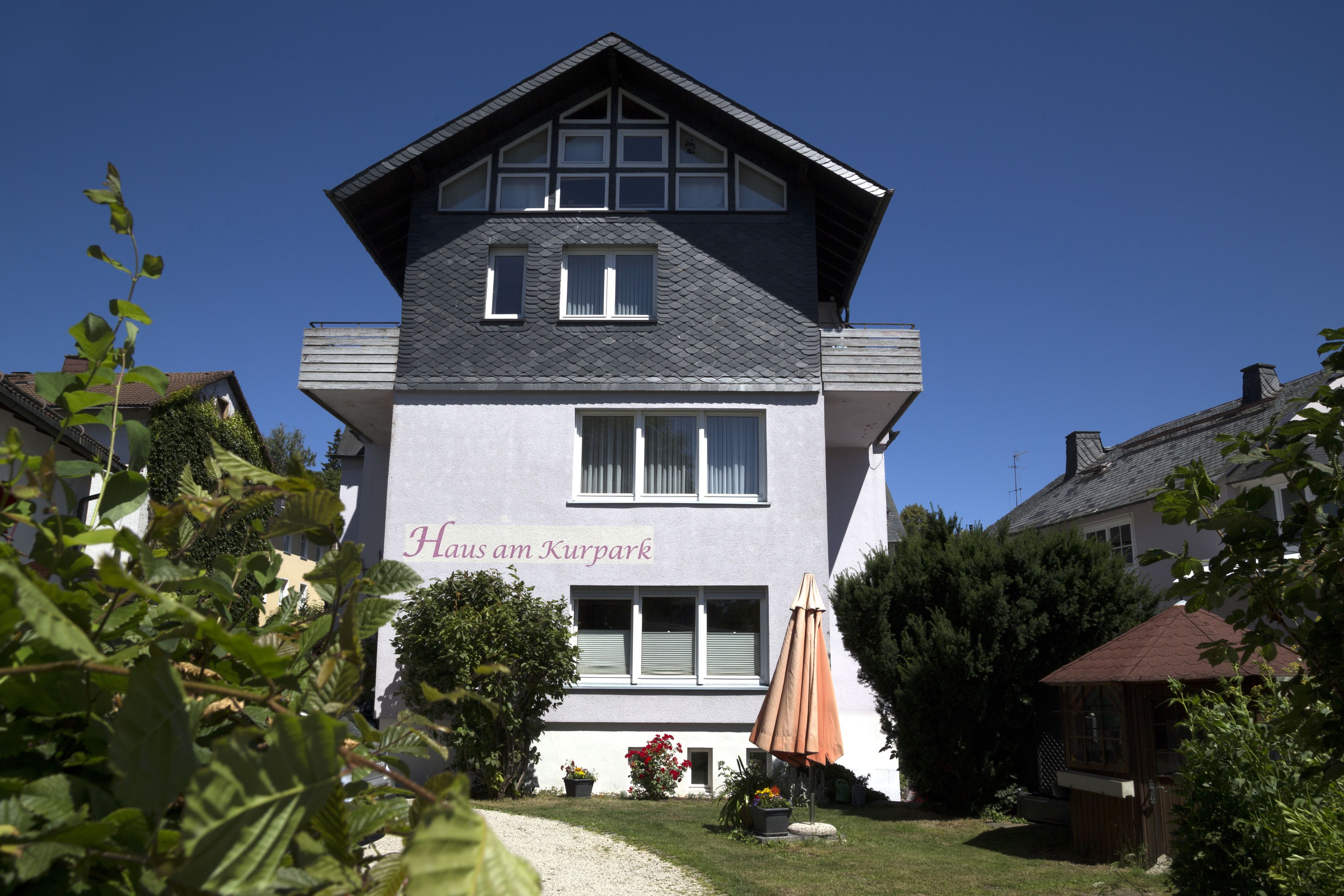 Un edificio de dos plantas con un letrero que dice "Haus am Kurpark".